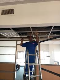 A techician installing drop ceilings
