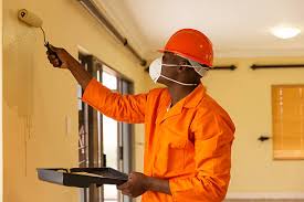 A male painter with a paint roller in hand painting