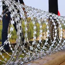 A roll of razor wire on top of a fence.
