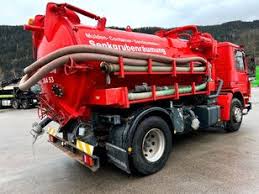 A small red waste truck