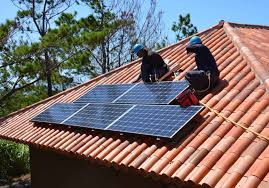 Two electricians fixing solar on the roof