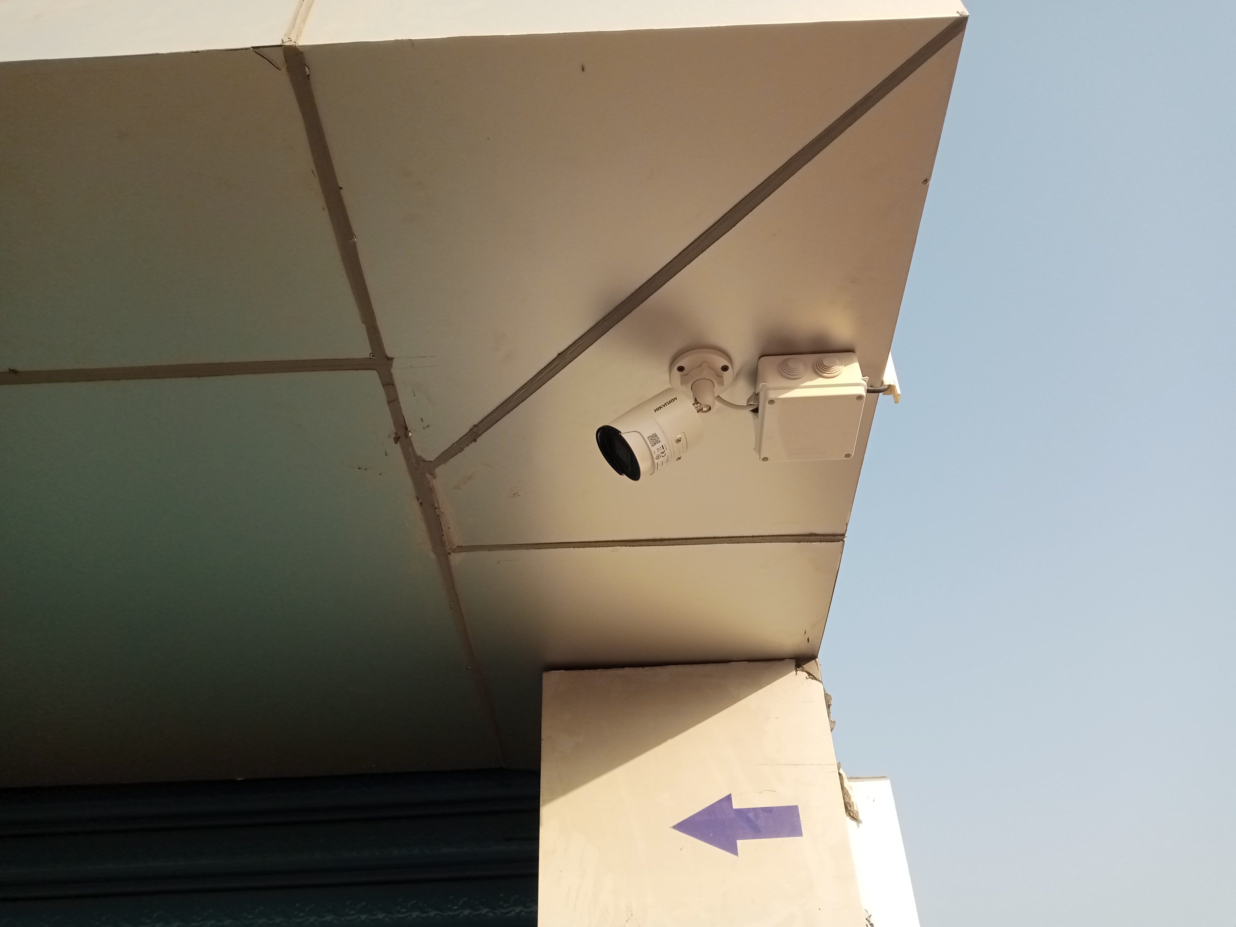 A hikvision bullet camera mounted on the exterior ceiling facing a corridor of a hotel in Juba, South Sudan