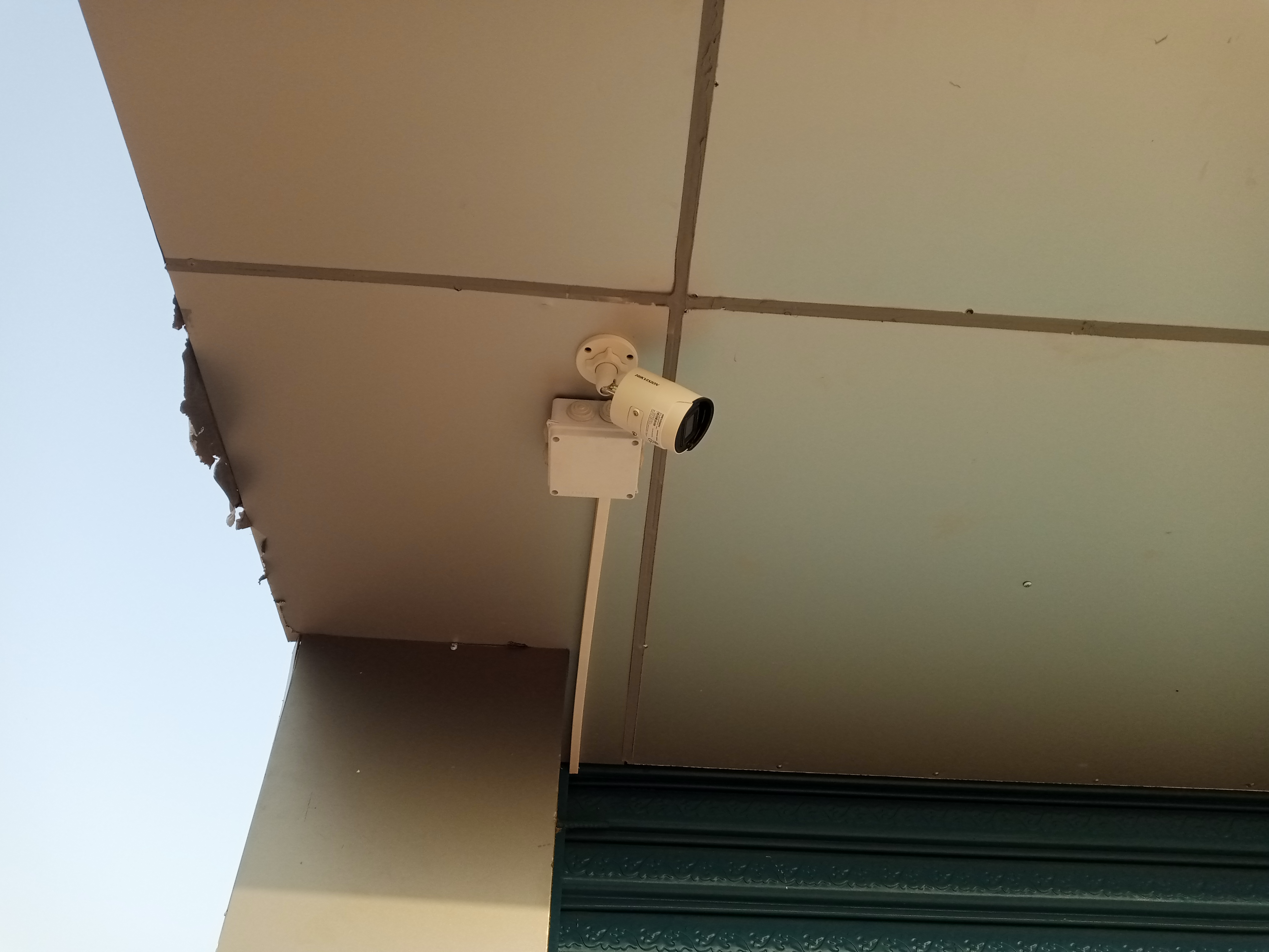 A bullet camera mounted on aluminum with adapter box next to it